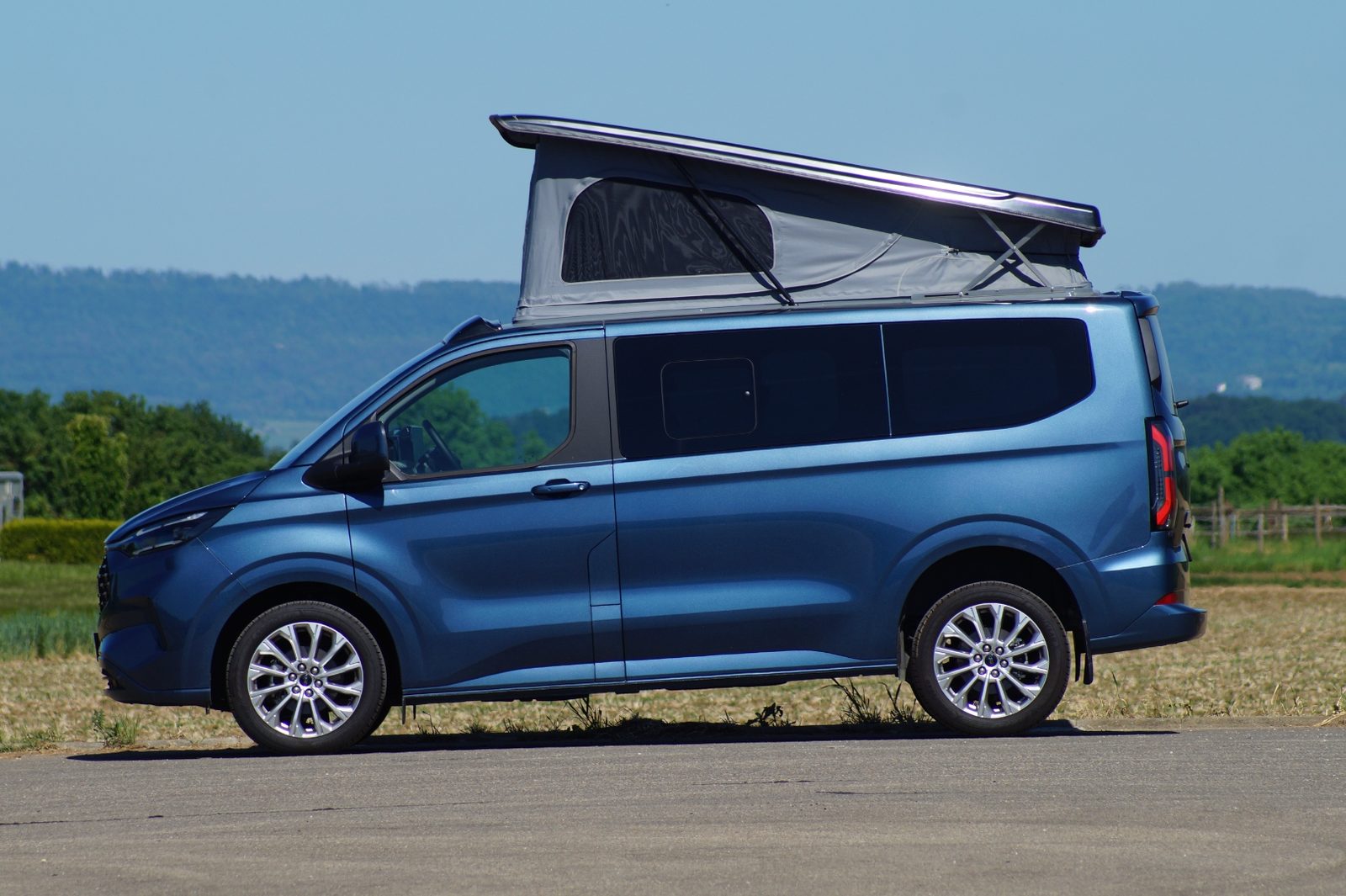 Dein Held Ford Tourneo Custom Titanium mit geöffnetem Aufstelldach in Seitenansicht